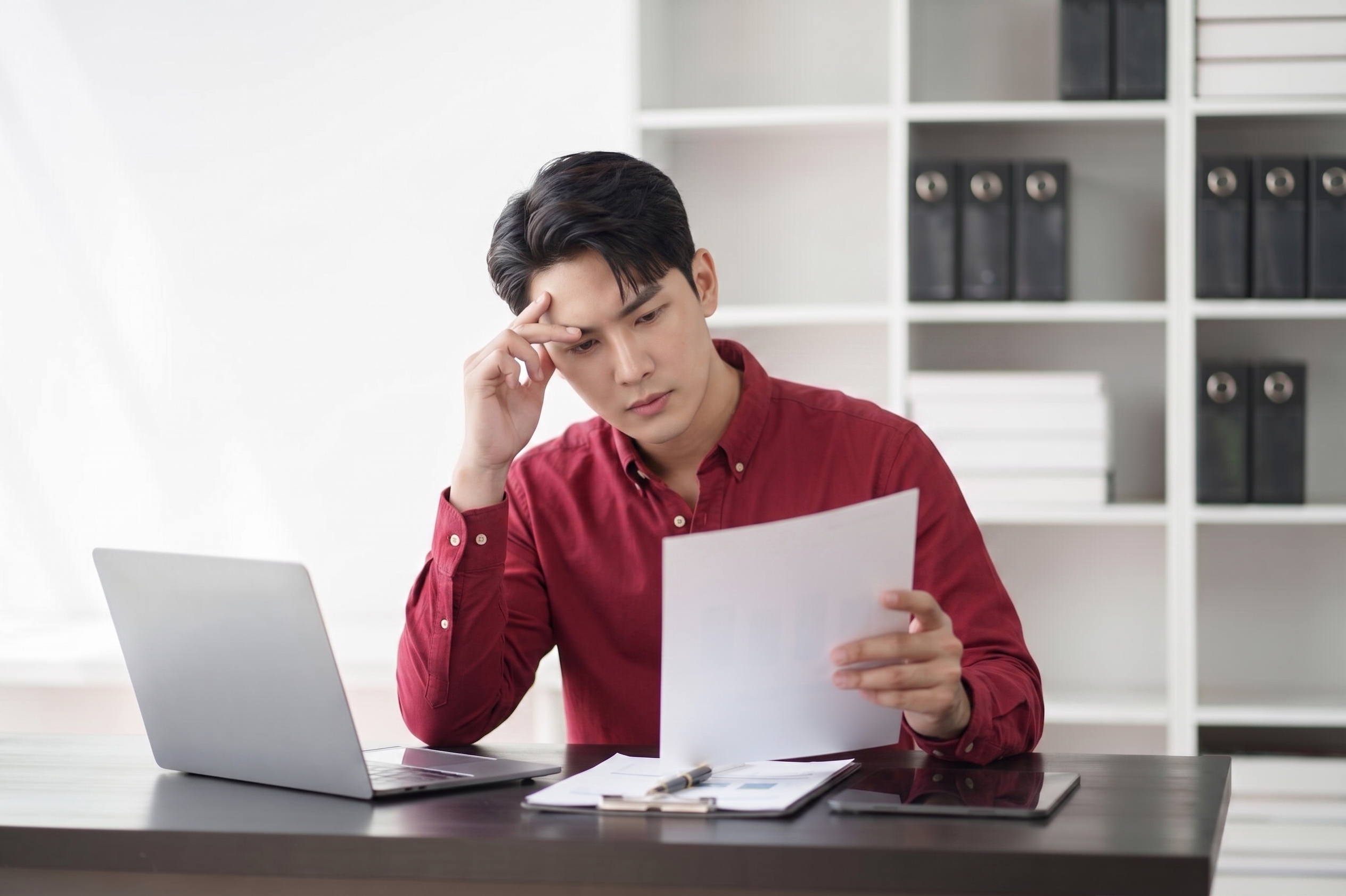 A person looking worried while reviewing a document on a tablet